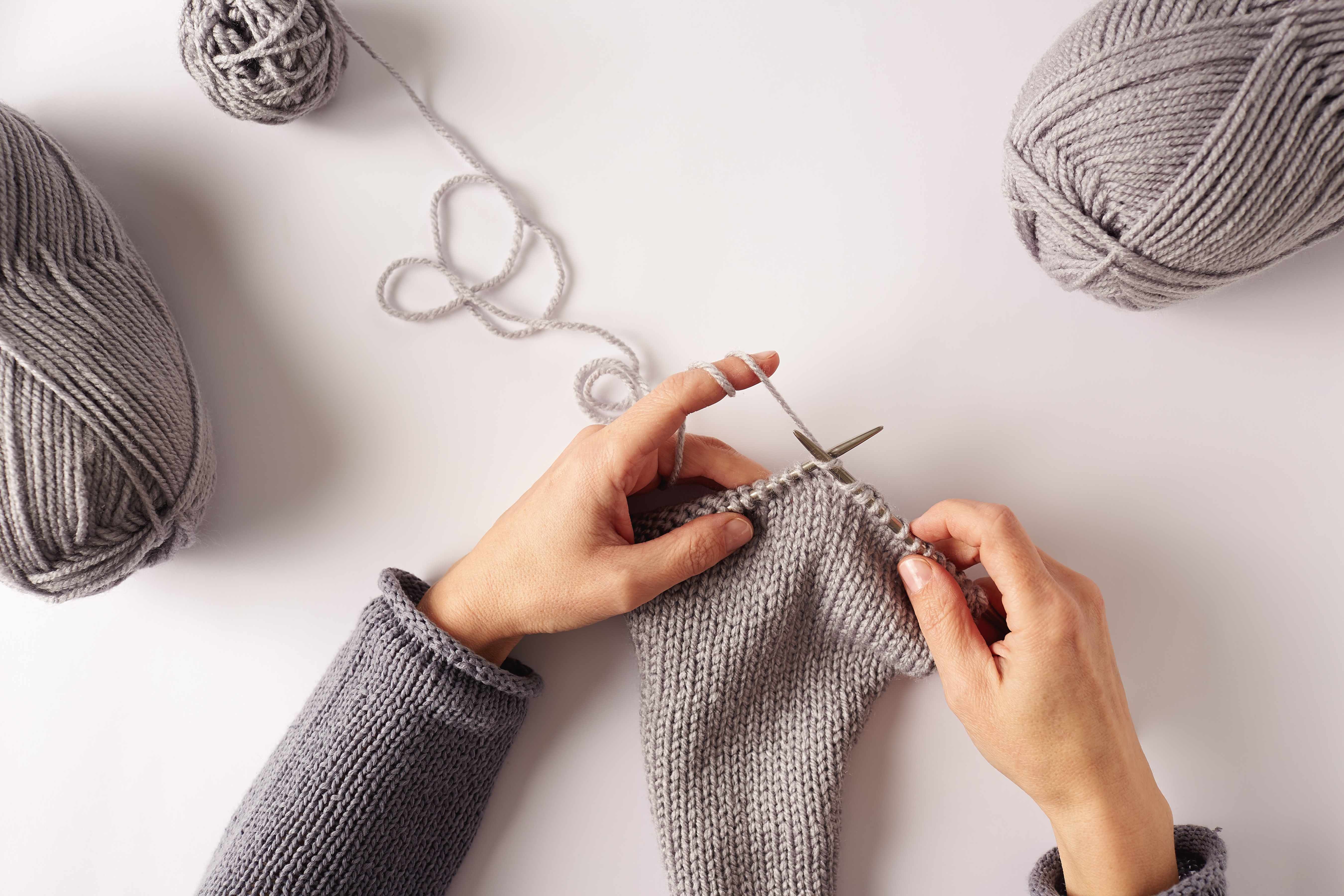 Knitting hands. Вязание процесс. Клубки спицы вязаные вещи. Вязальные спицы в руках. Вязание спицами руки.